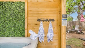 A hot tub area with wooden walls, a green hedge, and a sign indicating quiet hours. - 1 King and 1 Queen - Close to just about Everything (Fredericksburg)