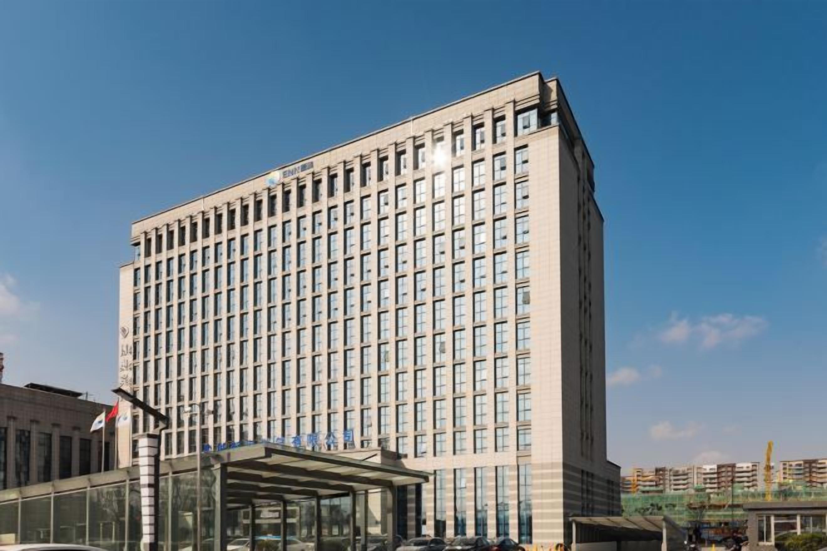 A multi-story hotel building with a glass entrance and a clear sky.