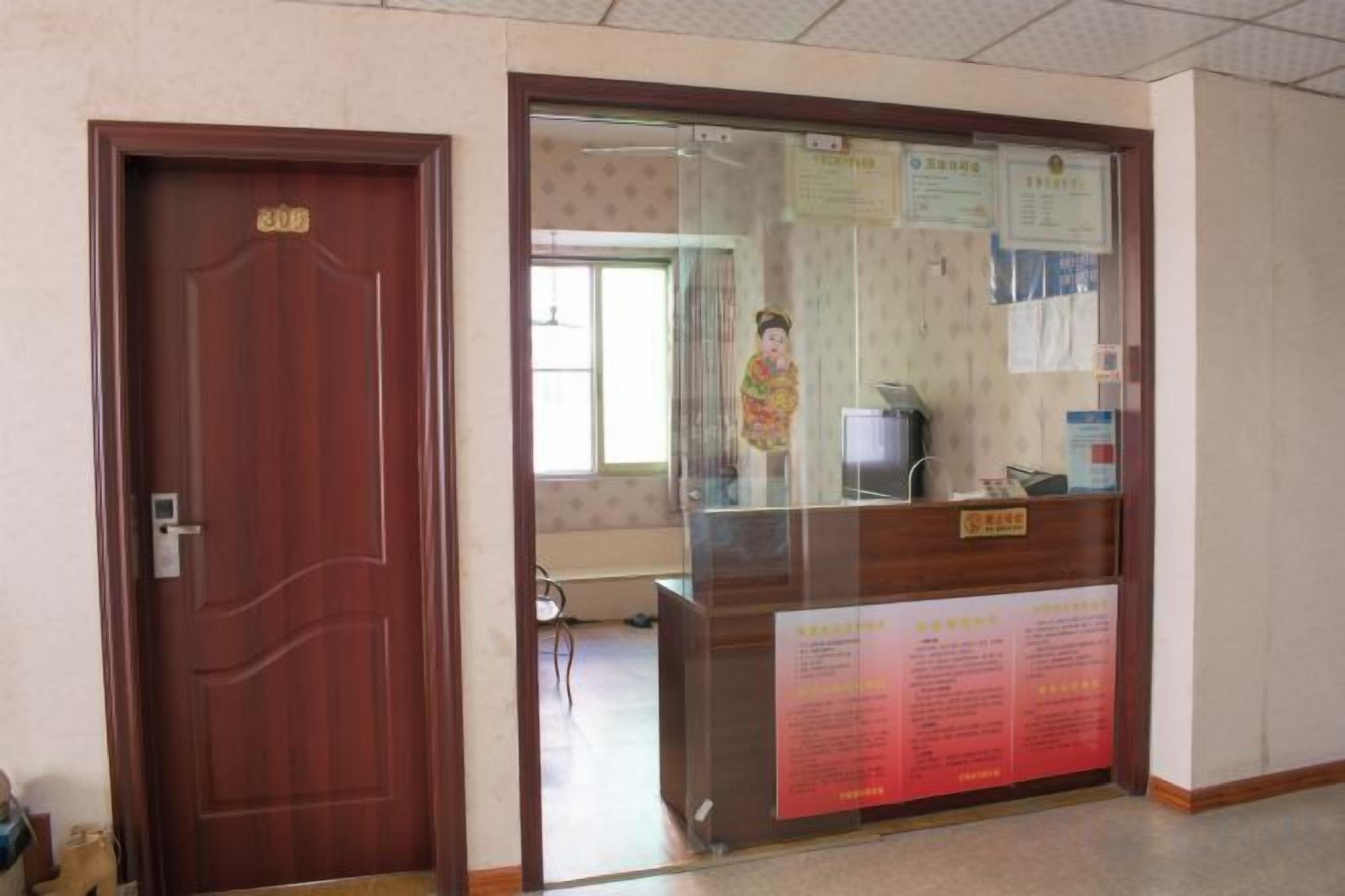 A reception area with a wooden door, a reception desk, and informational posters.