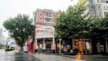 A multi-story building with a curved facade, a visible entrance, and signage indicating a business or commercial use.