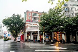 A multi-story building with a curved facade, a visible entrance, and signage indicating a business or commercial use. - Changtai Dongyuan Hotel (Zhangzhou)