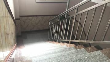 A staircase with metal railings and patterned wall tiles.