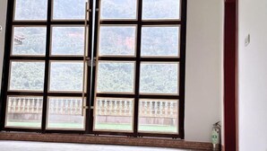 Ein großes Fenster mit Blick auf einen Garten und ein Gebäude.