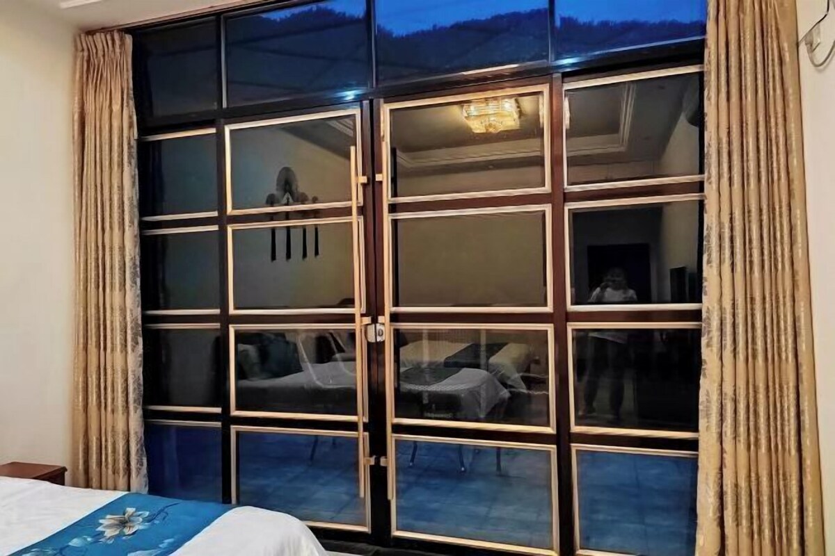 A room with a large sliding glass door leading to an outdoor area with chairs and a table.