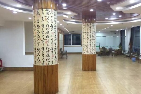 A spacious lobby with wooden pillars featuring calligraphy, a modern ceiling design, and a view of the interior. - Yushan Chunhui Express Hotel (Yushan)