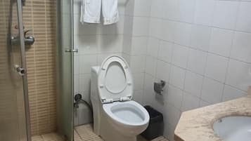 Un baño con inodoro, ducha y lavamanos.