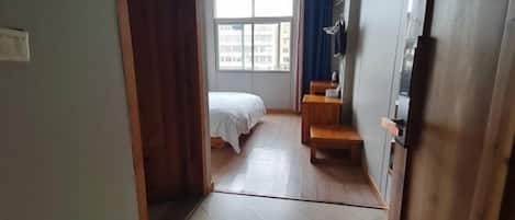 Una habitación de hotel con cama, escritorio y ventana.