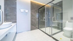 A modern bathroom with a glass-enclosed shower, a white sink, and a marble wall. - Hotels in Bama (Bama)