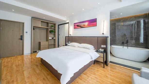 A modern bedroom with a large bed, a walk-in closet, a bathroom with a freestanding bathtub, and a painting on the wall. - Hotels in Bama (Bama)
