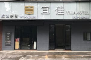 Entrada de hotel con fachada moderna, amplias puertas de vidrio y una recepción visible.