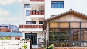 A modern multi-story building with a flat roof and large windows. - BCDJ The inn (Shengsi)
