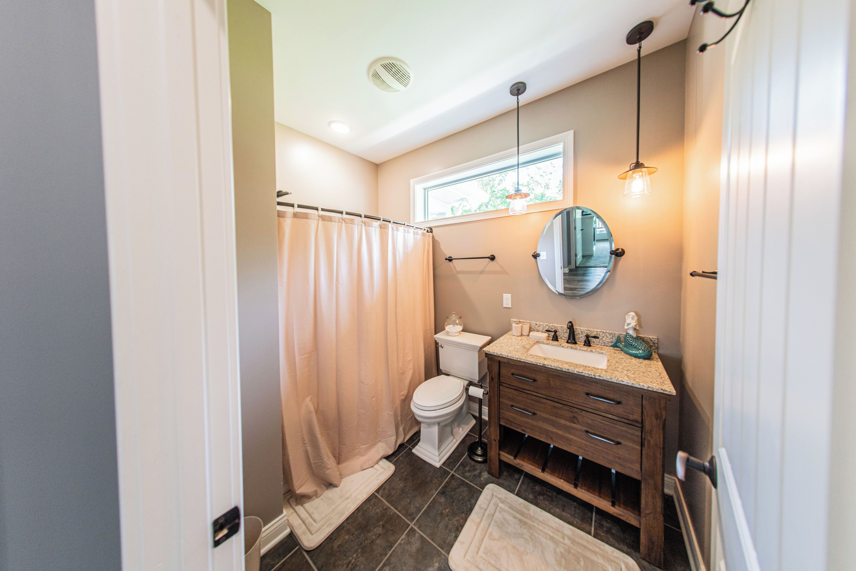 A bathroom with a toilet, sink, and shower curtain.