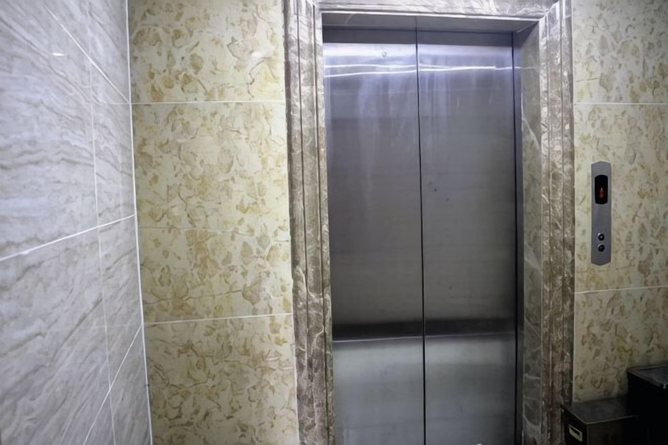 Un ascensor con interior metálico y un panel de control a la derecha.
