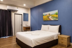 Quarto de hotel com cama, mesa de cabeceira e um quadro na parede.