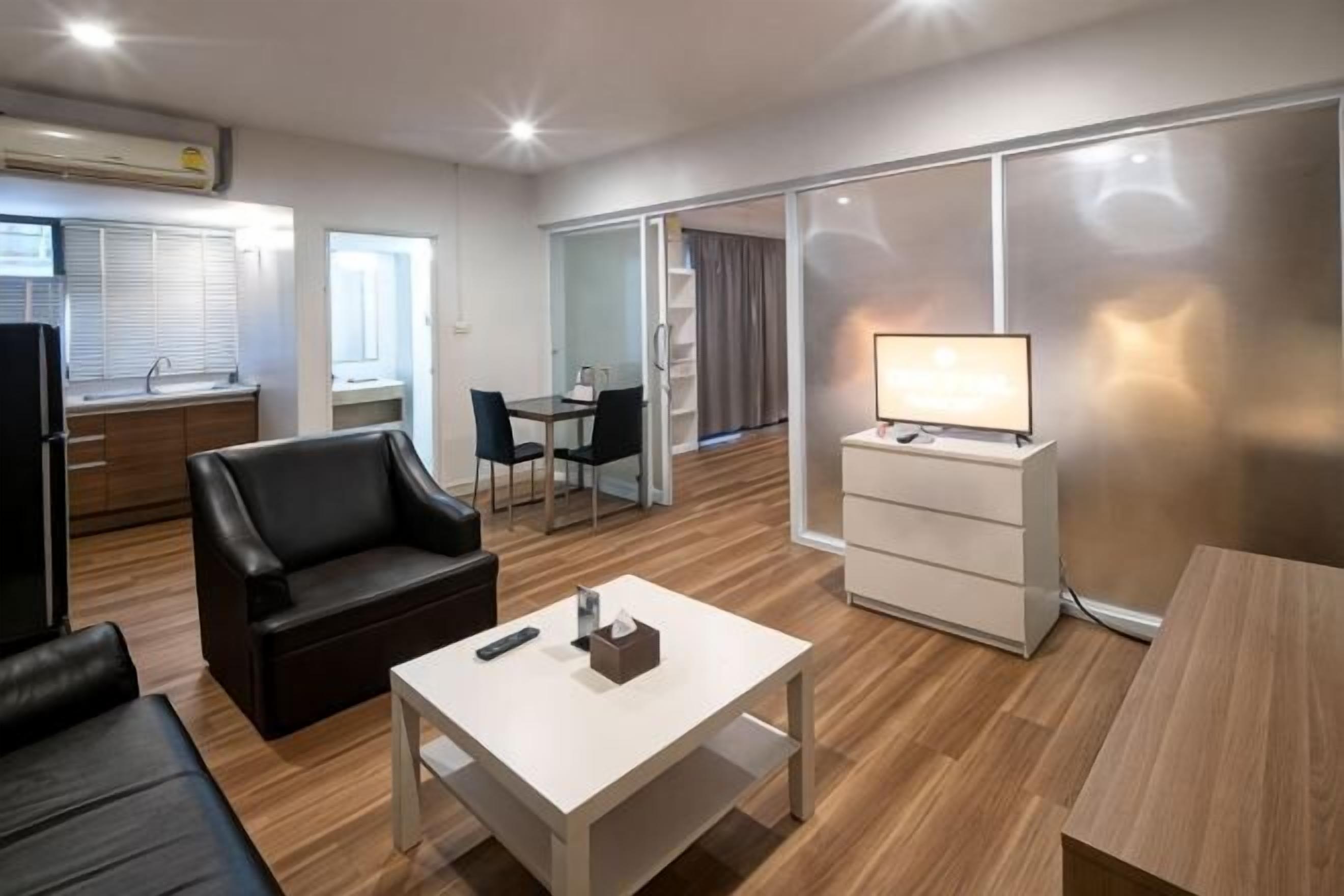 Un saló modern amb un sofà, una taula de centre, una televisió i una porta corredissa que dona a un balcó.