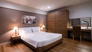 A bedroom with a bed, nightstands, a desk, and a wardrobe. - Crystal Resort (Nakhon Ratchasima)