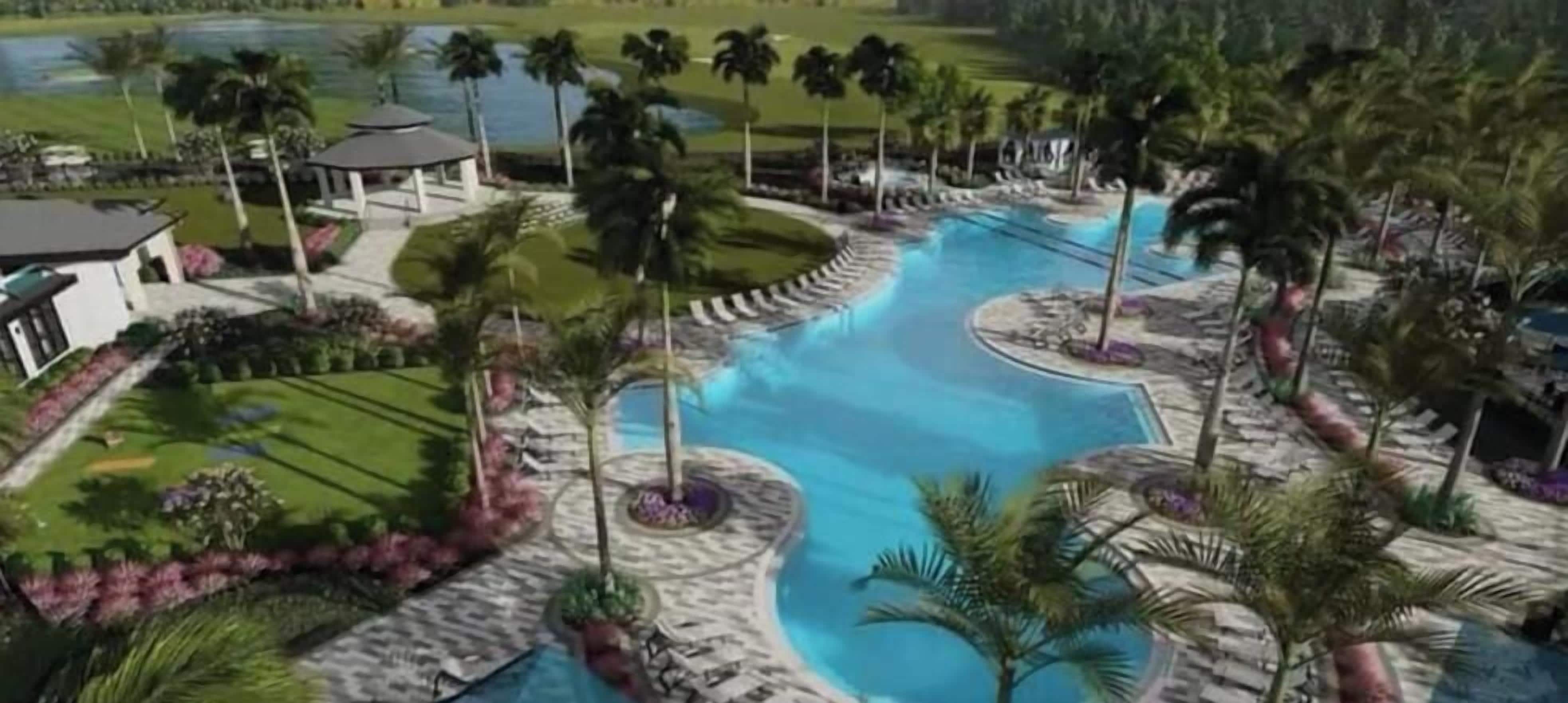 A resort with a swimming pool, palm trees, and a landscaped garden.
