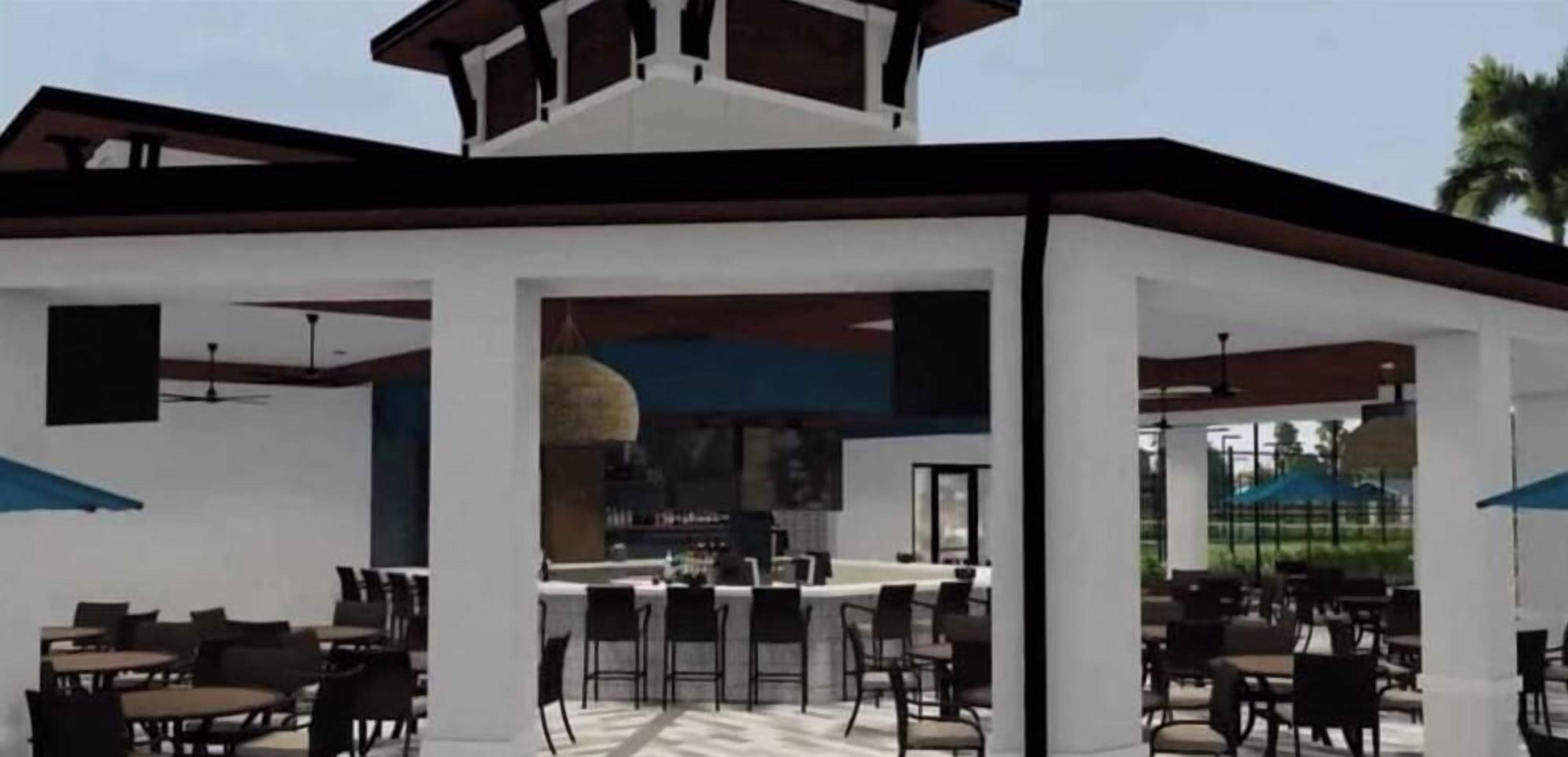 An outdoor dining area with multiple tables and chairs, a bar counter, and a covered seating area.