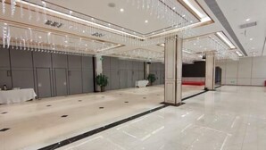 A spacious, well-lit hall with a polished floor, a reception area with a counter, and a seating area with tables and chairs. - Sopley li zhi Hotel (Zhengzhou)