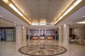 A spacious lobby with a central reception desk, large columns, and a decorative circular floor pattern. - Sopley li zhi Hotel (Zhengzhou)