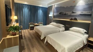 A hotel room with two beds, a desk with a chair, a TV, and a wall with a scenic mural. - Sopley li zhi Hotel (Zhengzhou)
