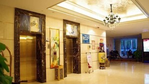 A hotel lobby with marble flooring, a chandelier, and artwork on the walls. - Sopley li zhi Hotel (Zhengzhou)