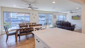 A spacious kitchen with a large island, dining area with chairs, and a seating area with a sofa and chairs. - Monthly Only - Remodeled Lower Unit Just One House To The Sand With AC (Newport Beach)