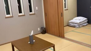Una habitación con una mesa de madera, una ventana, una puerta y un suelo de tatami.