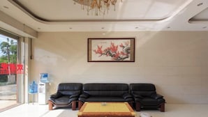 A modern lobby with a sofa, a coffee table, and a framed artwork on the wall.