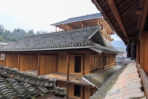 Un bâtiment traditionnel en bois, doté d’un toit en tuiles et d’un balcon en bois.
