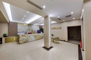 A hotel lobby with a reception desk, a large pillar, and a seating area. - Meixiangchun Collection Hotel (Datong Yungang District) (Datong)