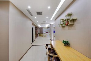A hotel corridor with a reception desk, seating area, and a map on the wall. - Meixiangchun Collection Hotel (Datong Yungang District) (Datong)