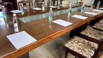 A conference room with a long table, chairs, water bottles, and papers.