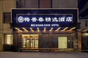 A hotel entrance with a neon sign, a large glass door, and a visible entrance ramp. - Meixiangchun Collection Hotel (Datong Yungang District) (Datong)
