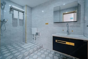 Un baño con ducha, lavamanos, espejo y suelo de baldosas.