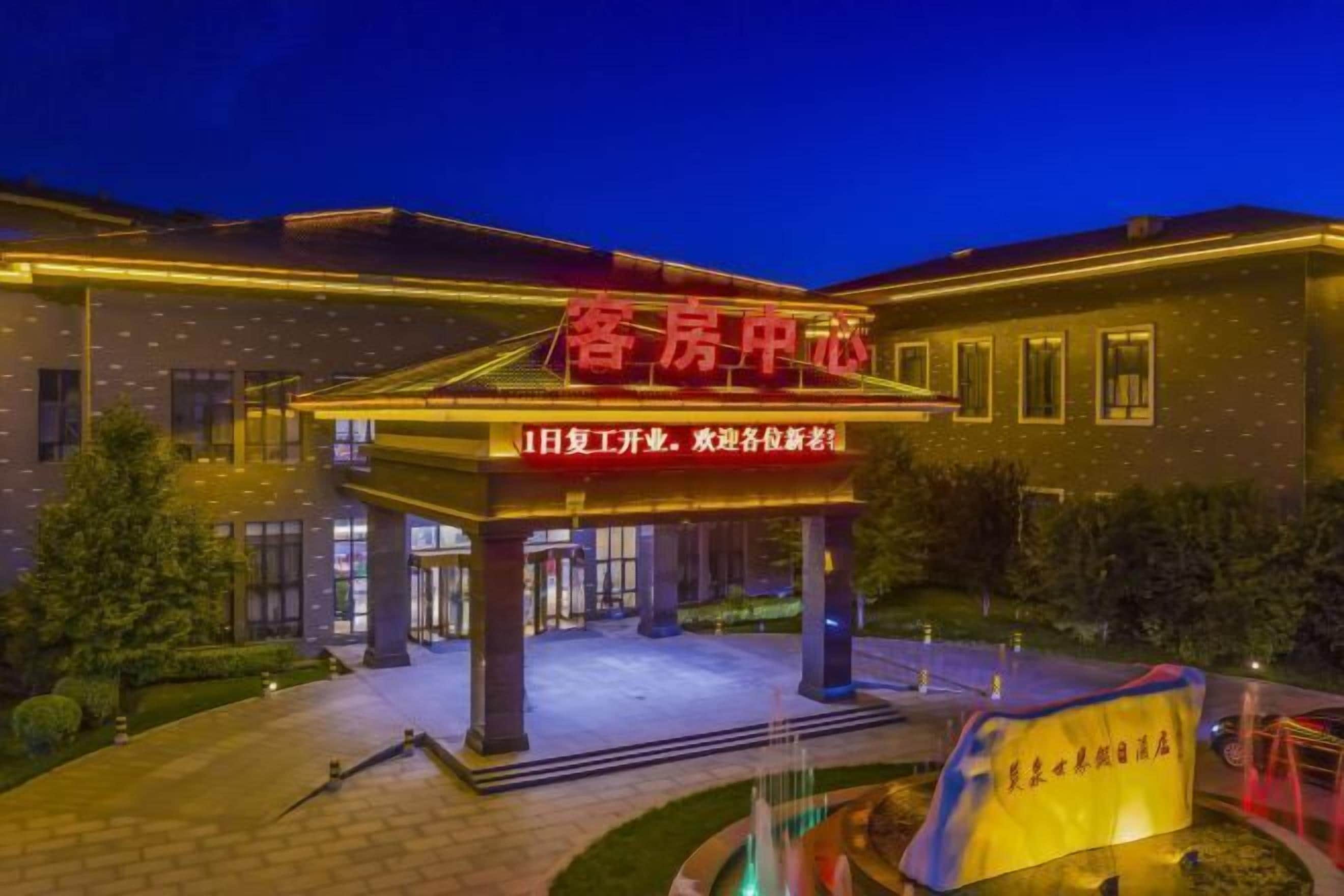 L’entrée d’un hôtel, dotée d’un espace abrité et d’une enseigne en caractères chinois.