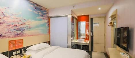 A hotel room with two beds, a bathroom with a mirror, and a TV.