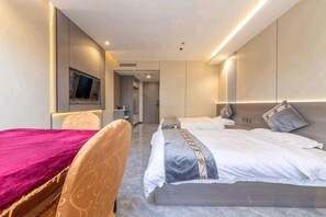 Une chambre d’hôtel avec un lit, un bureau et une télévision.
