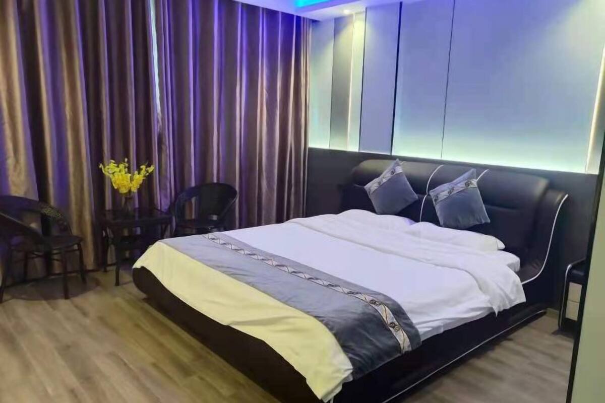 Une chambre à coucher moderne avec un grand lit, un bureau et une chaise.