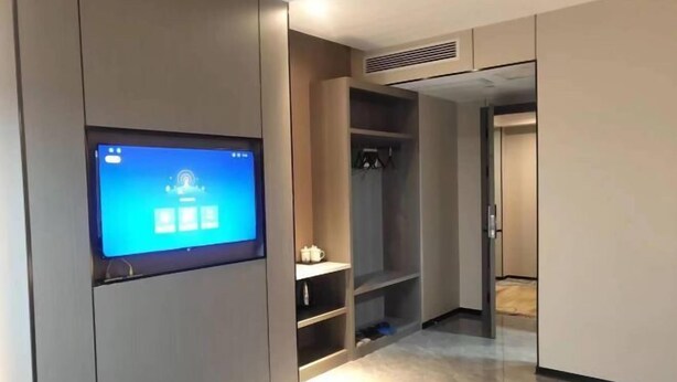 Ein modernes Zimmer mit eingebauten Regalen, einem Flachbildfernseher und einem Kleiderschrank.