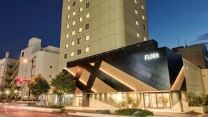 Ein Hotel mit modernem Design, mit einem auffälligen 'FLORA'-Schild an der Fassade.