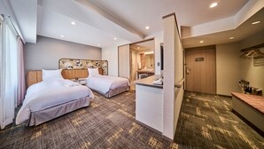 Ein Hotelzimmer mit zwei Betten, einem Schreibtisch und einem Badezimmer.