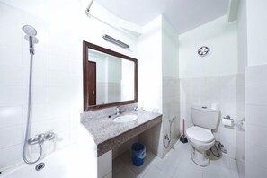 Ein Badezimmer mit Dusche, Toilette, Waschbecken und Spiegel.