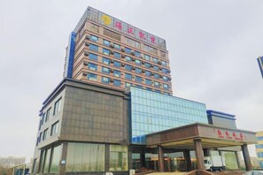 A multi-story hotel with a prominent entrance and a glass facade. - Haizheng Hotel (Weifang)