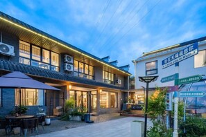 A building with multiple windows, outdoor seating, and signage. - Wuxi Dayin Mountain Residence Garden Homestay (Wuxi)