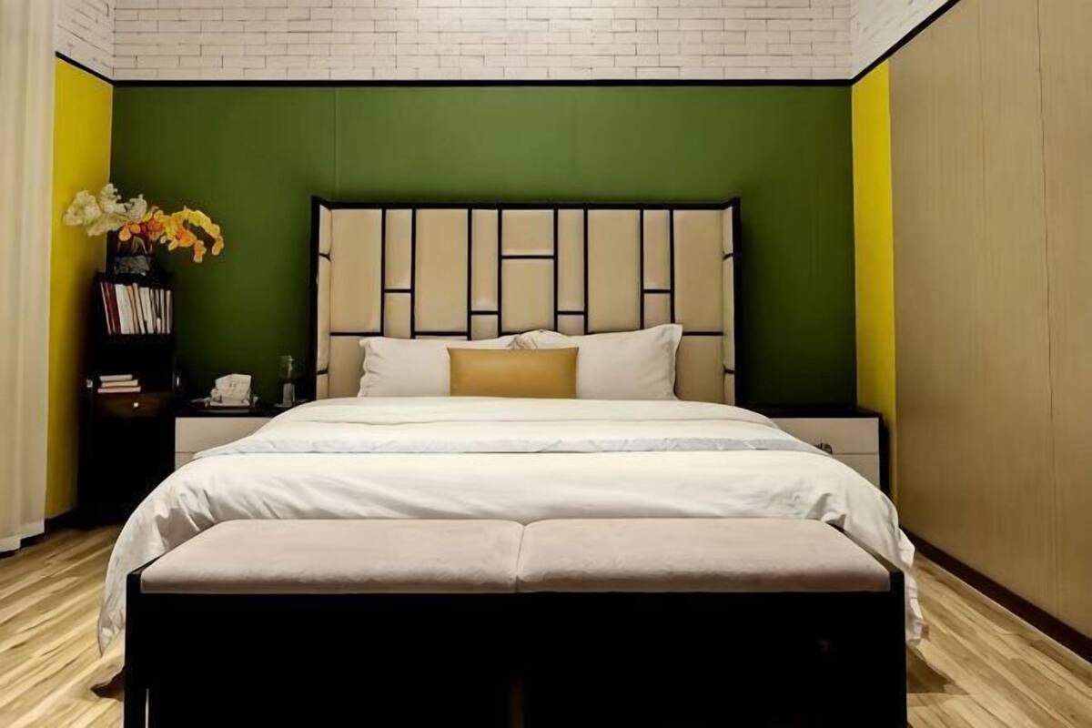 A neatly arranged bedroom with a bed, bedside tables, and a bench.