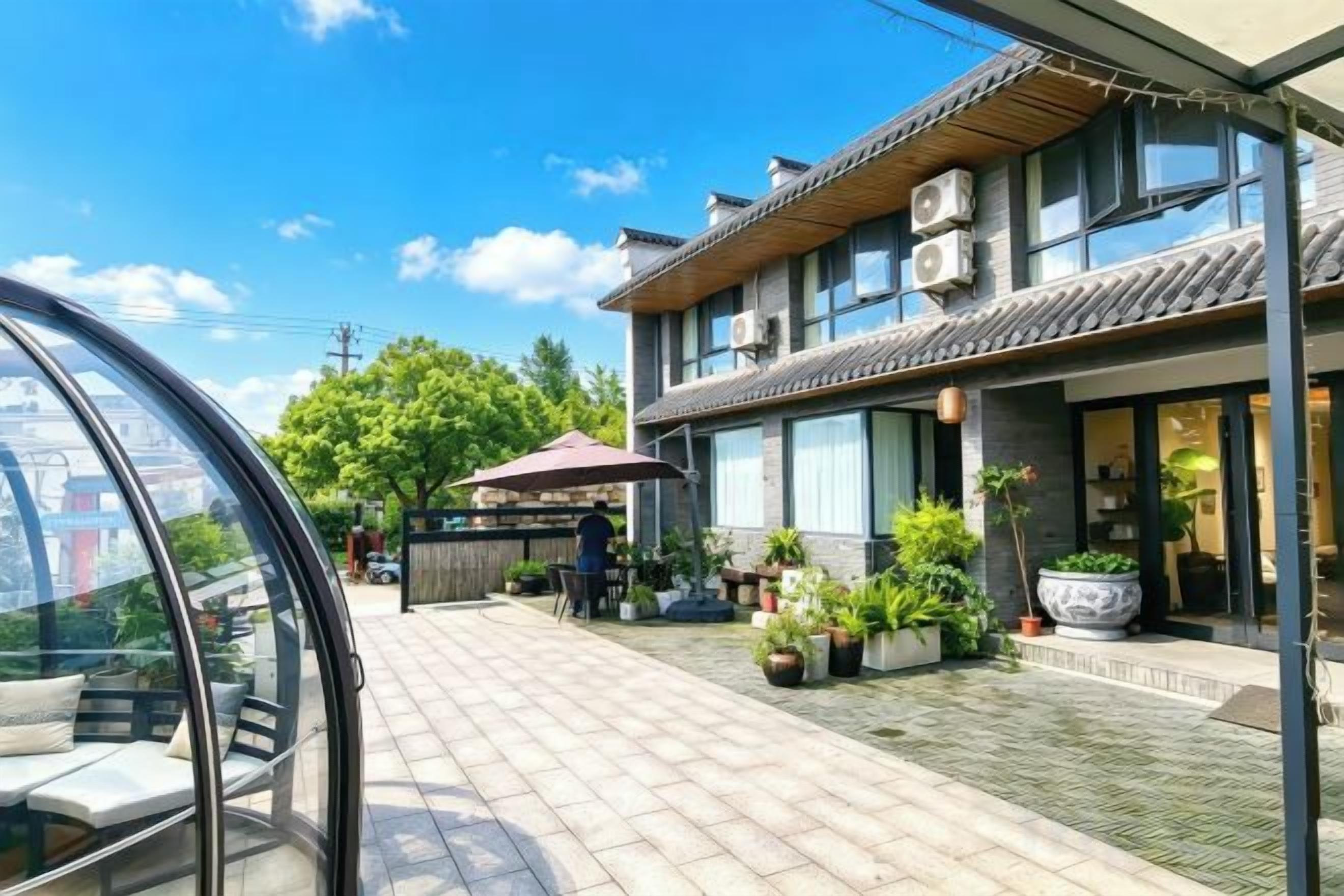 A traditional building with a tiled entrance, outdoor seating, and potted plants.