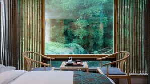 A room with a large window, a bed, two chairs, and a small table with a teapot and cups. - Wuxi Dayin Mountain Residence Garden Homestay (Wuxi)