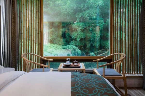 A room with a large window, a bed, two chairs, and a small table with a teapot and cups. - Wuxi Dayin Mountain Residence Garden Homestay (Wuxi)