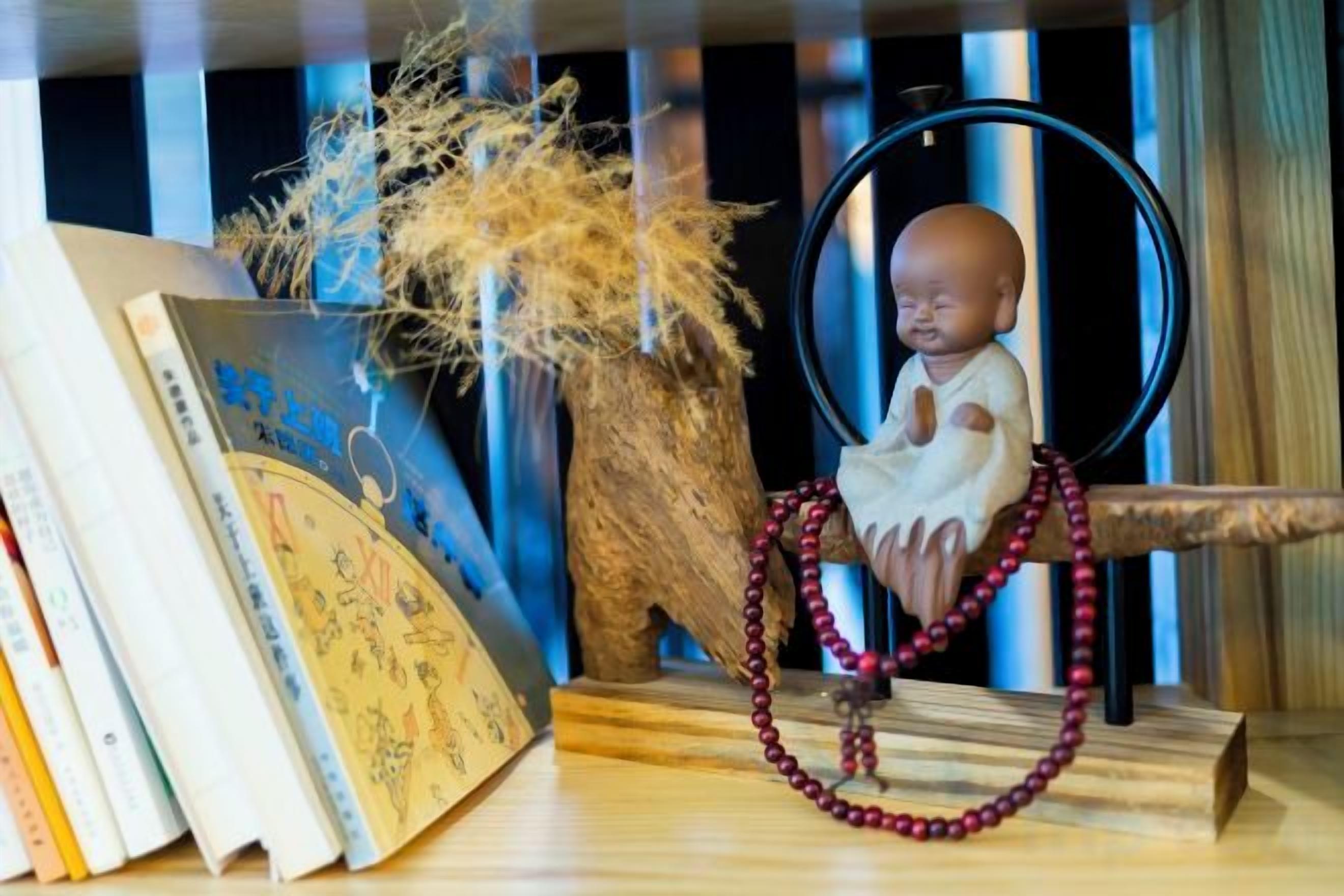 Una mesa de madera con un objeto decorativo, un cuadro enmarcado y un libro.